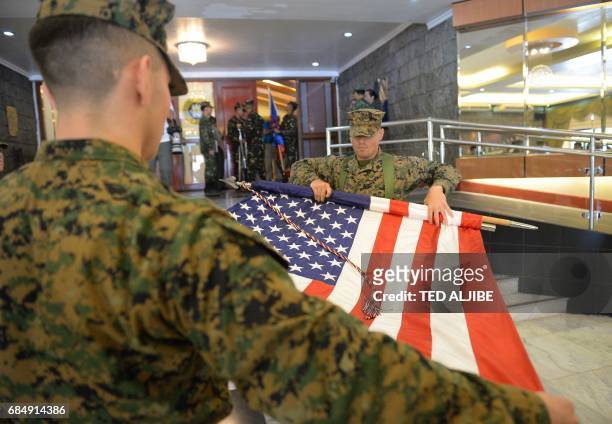 Members of US marines guards fold their national flag during the closing ceremony of the annual joint US-Philippines military exercise in Manila on...
