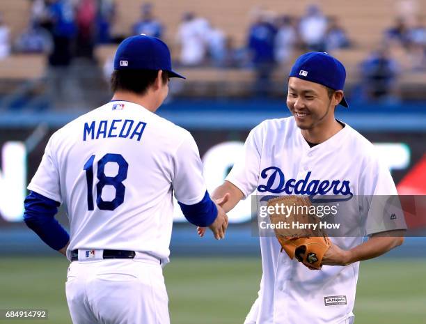 Olympic swimmer Kosuke Kitajima of Japan shakes hands with Kenta Maeda of the Los Angeles Dodgers after throwing out a ceremonial first pitch before...