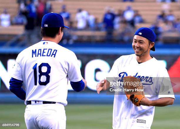 Olympic swimmer Kosuke Kitajima of Japan shakes hands with Kenta Maeda of the Los Angeles Dodgers after throwing out a ceremonial first pitch before...