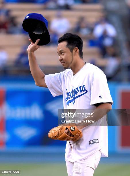 Olympic swimmer Kosuke Kitajima of Japan reacts after throwing out a ceremonial first pitch before the game against the Miami Marlins at Dodger...