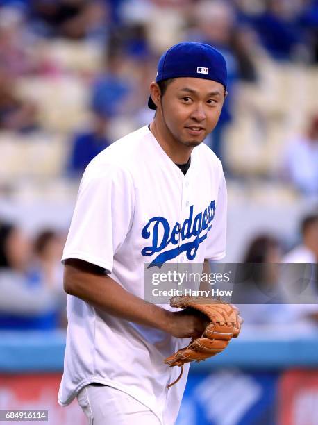 Olympic swimmer Kosuke Kitajima of Japan reacts as he head to the pitching mound to throw out a ceremonial first pitch before the game against the...