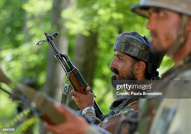 Indian Army troops stand guard along the road that leads to the Line of Control June 10, 2002 outside Srinagar, Kashmir, India. The troops are on...