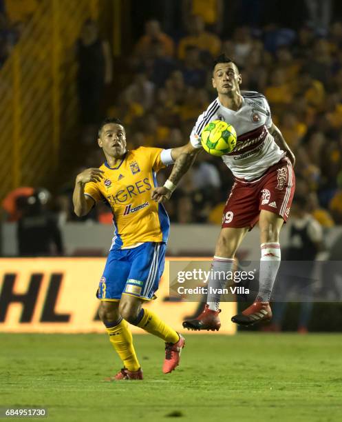 Milton Caraglio of Tijuana fights for the ball with Juninho of Tigres during the semi finals first leg match between Tigres UANL and Tijuana as part...