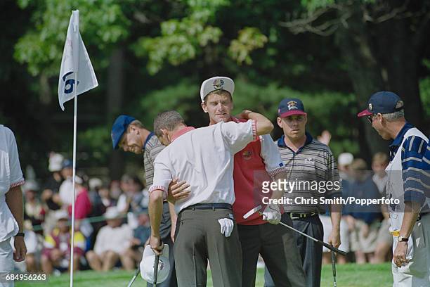 Swedish golfer Jesper Parnevik pictured centre, embraces his playing partner, Spanish golfer Sergio Garcia after gaining points in action for Team...
