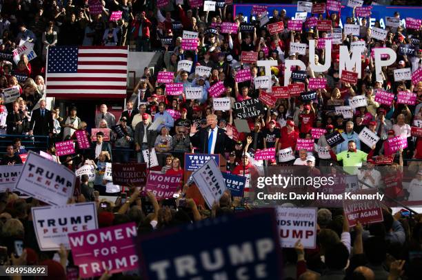 American real estate developer and presidential candidate Donald Trump raises his hands as he speaks from the podium during a campaign rally at...