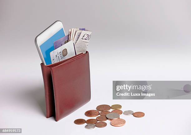 bulging wallet of money, bank cards and phone - full wallet stock pictures, royalty-free photos & images