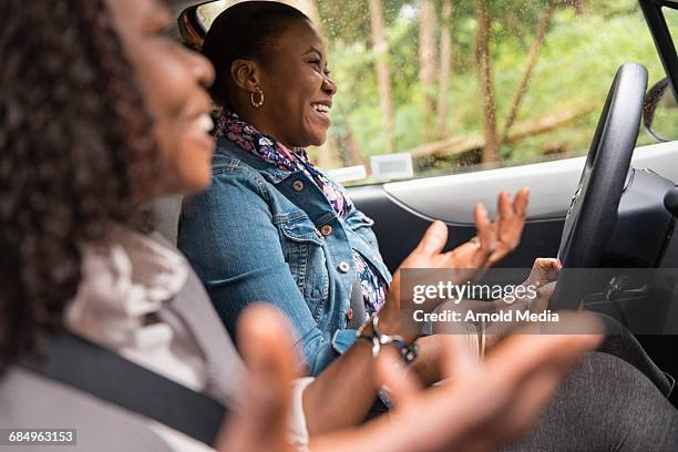 women laughing and talking in car while driving - two cars ストックフォトと画像