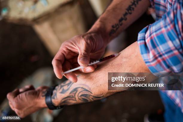 Man injects a shot of heroin near a heroin encampmentin the Kensington neighborhood of Philadelphia, Pennsylvania, on April 14, 2017. In North...