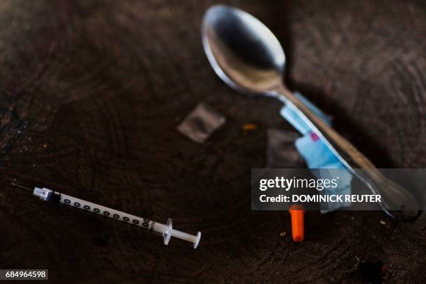 Needle, spoon, and narcotics bag are seen near a heroin encampment in the Kensington neighborhood of Philadelphia, Pennsylvania, on April 10, 2017....