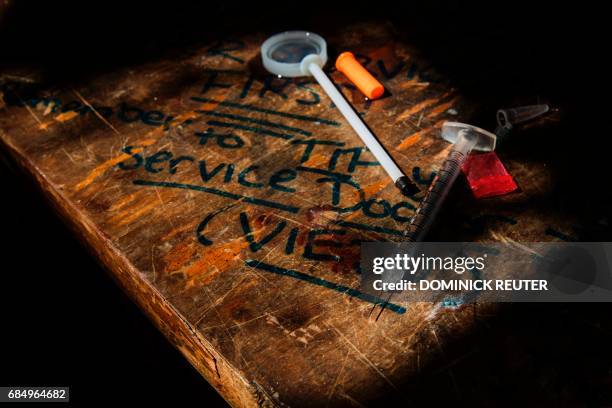 Needle, narcotics bag, and blood stain are seen with a reminder to tip the "Service Docs" at a heroin encampment in the Kensington neighborhood of...