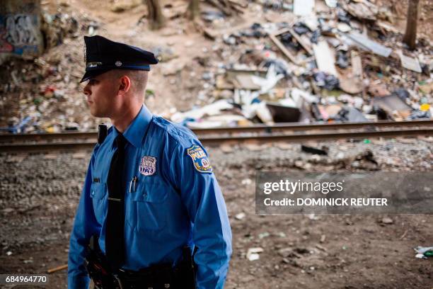 Philadelphia Police officer patrols under a bridge near a heroin encampment in the Kensington neighborhood of Philadelphia, Pennsylvania, on April...