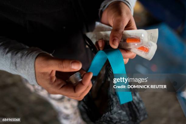 Jessica, a homeless heroin addict, shows her kit of clean needles, mixing cap and tourniquet in the Kensington neighborhood of Philadelphia,...