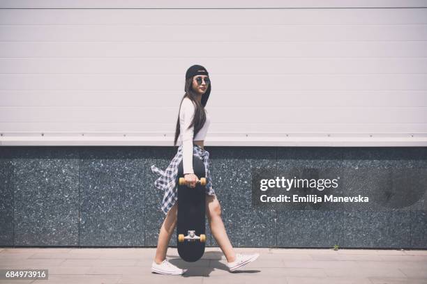 young girl walking away with her skateboard - skater girl stock pictures, royalty-free photos & images