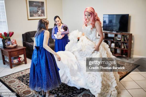 family members preparing young womans quinceanera gown in living room - quinceanera - fotografias e filmes do acervo