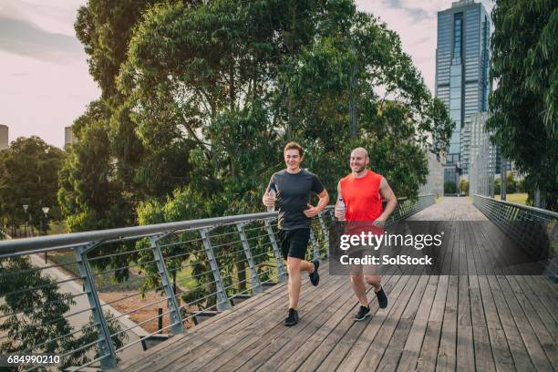 amici che fanno jogging nel parco - urban running foto e immagini stock