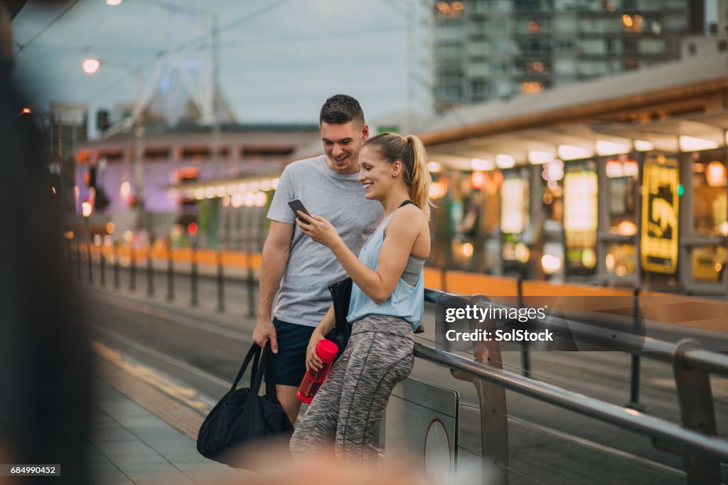 Two Friends Dressed in Athleisure Clothing Waiting for a Tram