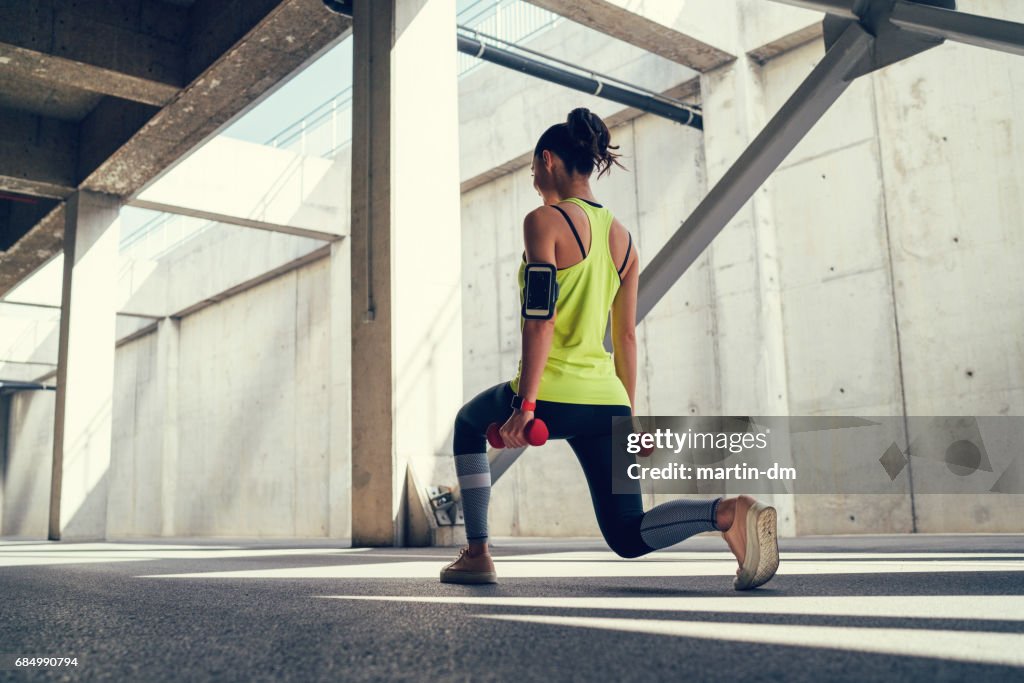 Sportswoman exercising with dumbbells