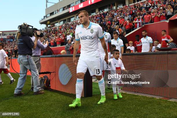 Seattle Sounders forward Jordan Morris walks out to the field while holding hands with a child prior to a game against the Seattle Sounders and the...