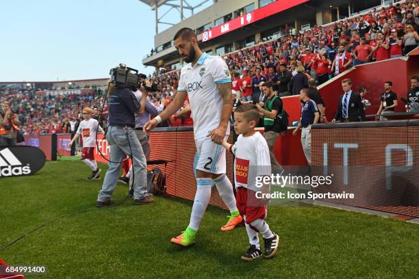 Seattle Sounders midfielder Clint Dempsey walks out to the field while holding hands with a child prior to a game against the Seattle Sounders and...