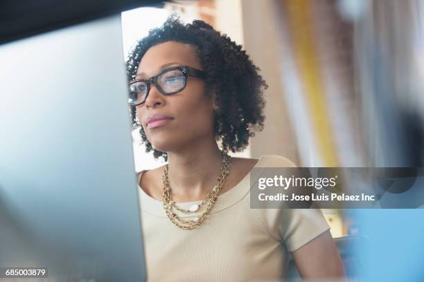 mixed race businesswoman working at computer - business person on computer screen stockfoto's en -beelden