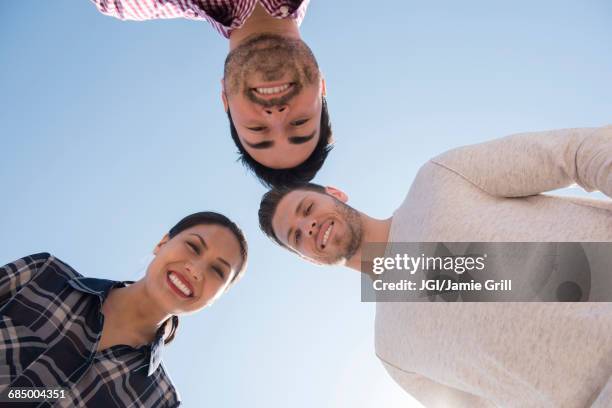smiling friends losing under blue sky - man looking up imagens e fotografias de stock