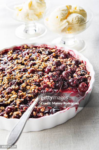 spoon in cherry crisp - cobbler stock-fotos und bilder