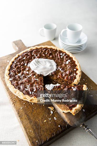 caramel pecan pie on cutting board - pecannusstorte stock-fotos und bilder