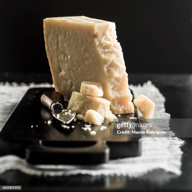 parmesan cheese crumbles on cutting board - parmesano fotografías e imágenes de stock