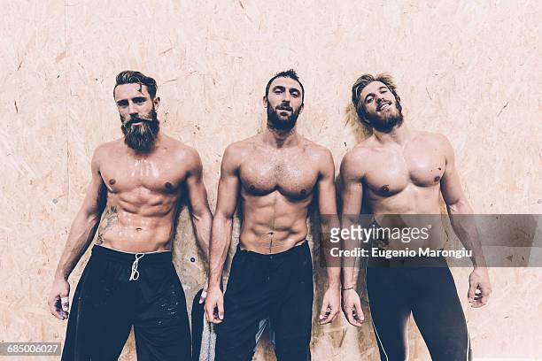 portrait of three macho male cross trainers in gym - männlichkeit stock-fotos und bilder