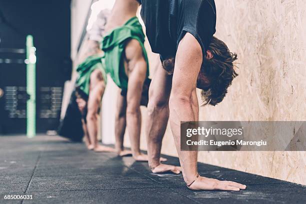 three male cross trainers doing handstands in gym - cross trainer stock-fotos und bilder
