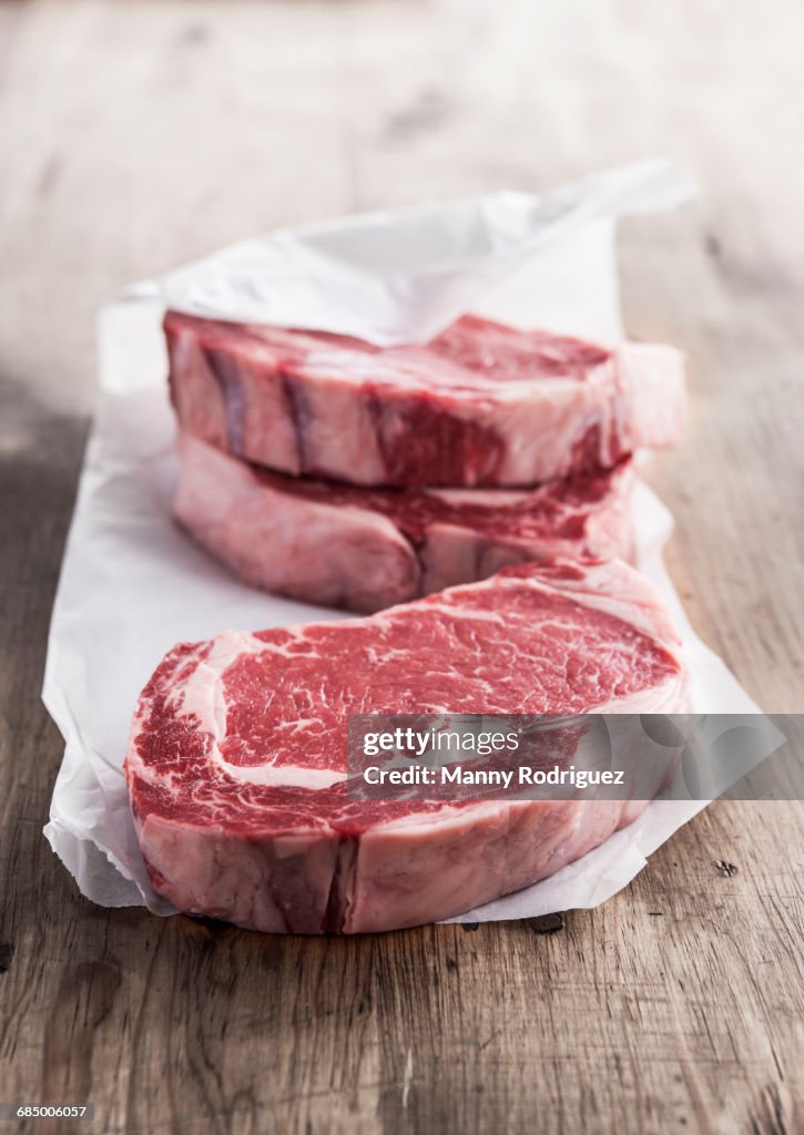 Raw rib eye steaks on butcher paper