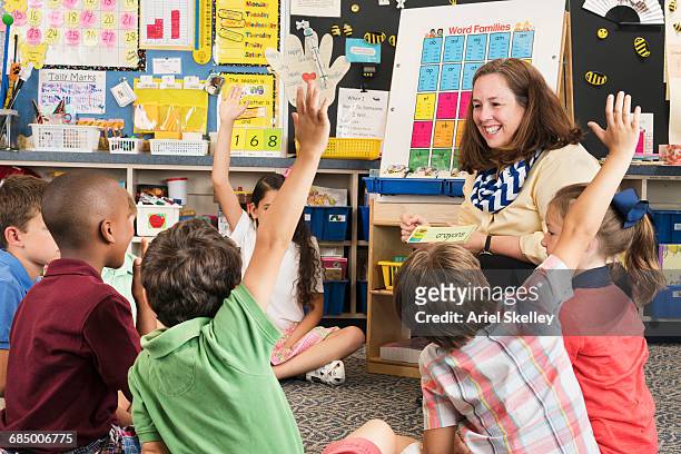 teacher and students using flash cards in classroom - bambini seduti in cerchio foto e immagini stock
