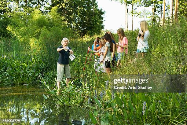 teacher and students collecting water specimen in wetland - school students science stock pictures, royalty-free photos & images