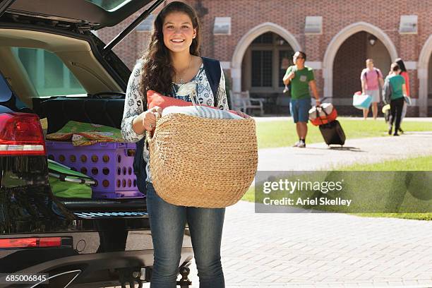 teenage girl unloading car at college dormitory - basket universitario imagens e fotografias de stock