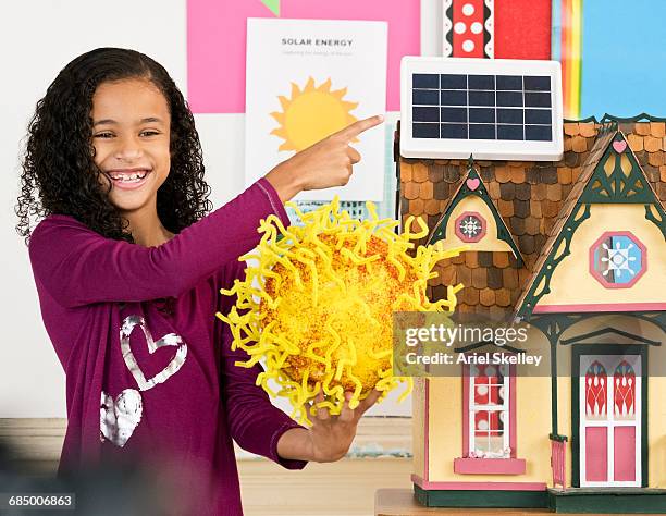 smiling mixed race girl showing solar power science project - projeto científico escolar imagens e fotografias de stock