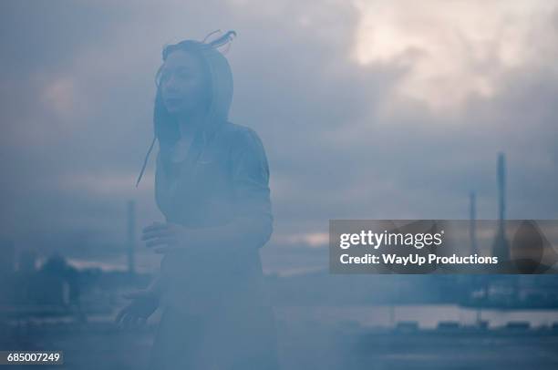 young female runner running on misty stormy dockside - atmosphere pollution stock pictures, royalty-free photos & images