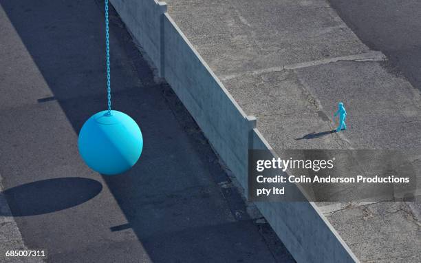 blue mixed race man walking to wall near wrecking ball - wrecking ball stock pictures, royalty-free photos & images