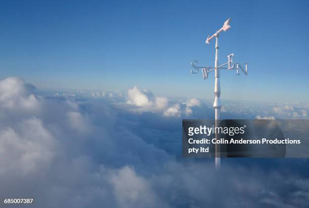 weather vane above clouds in sky - 道しるべ ストックフォトと画像