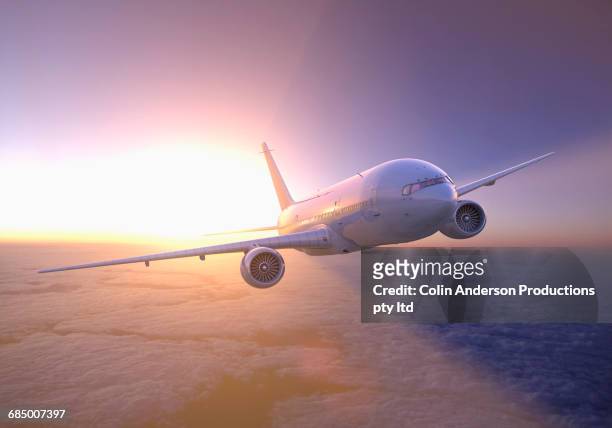 airplane flying above clouds at sunset - airplane sky - fotografias e filmes do acervo