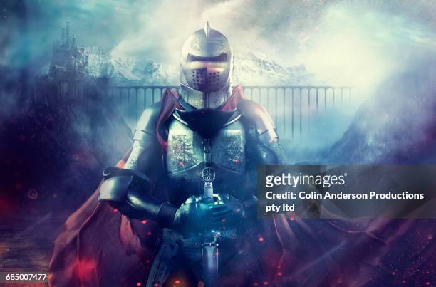 caucasian warrior wearing armor and cape on foggy battlefield - shielding stock pictures, royalty-free photos & images