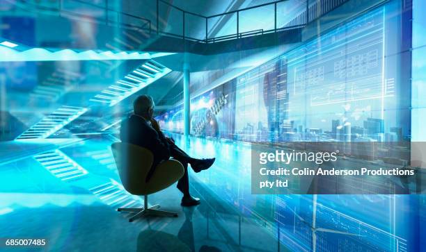caucasian businessman sitting in chair in futuristic office - window display stock-fotos und bilder