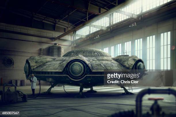 scientist researching spaceship in hangar - spaceship stock-fotos und bilder