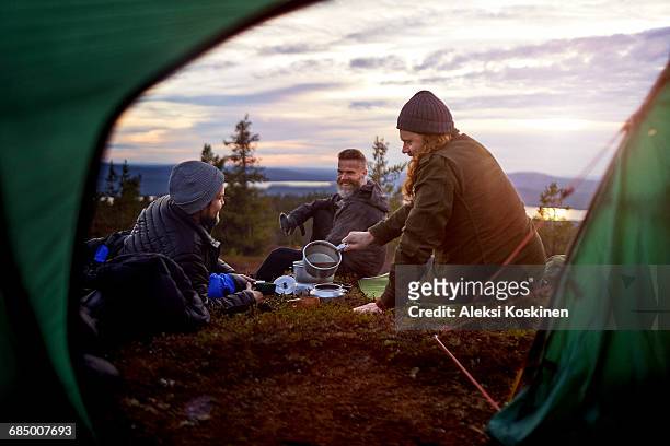 hikers preparing meal, chatting in front of tent, keimiotunturi, lapland, finland - finland stock pictures, royalty-free photos & images