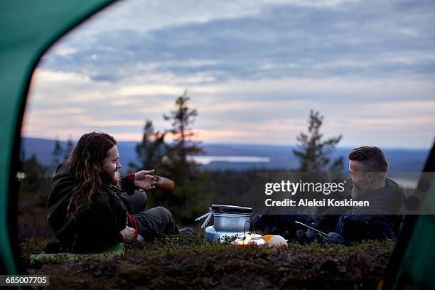 hikers relaxing, chatting in front of tent, keimiotunturi, lapland, finland - autumn finland stock pictures, royalty-free photos & images
