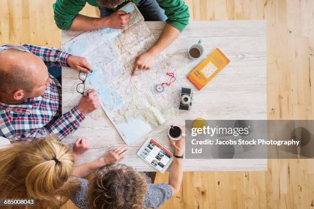 caucasian couple reading map at table - holiday planning ストックフォトと画像