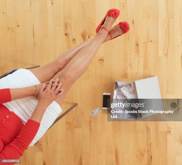 hispanic woman examining new red shoes - red shoe stockfoto's en -beelden