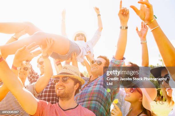 caucasian woman crowd surfing at concert - être porté par la foule photos et images de collection