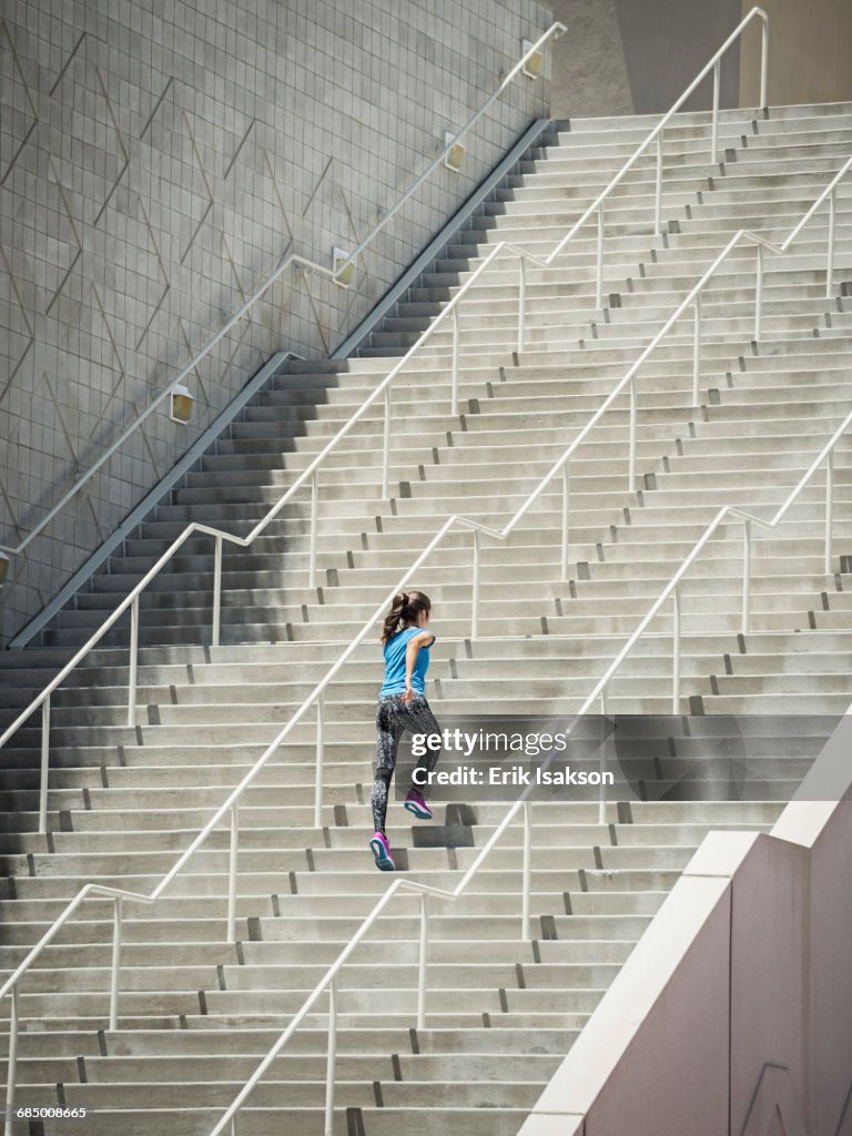 Caucasian woman running on staircase