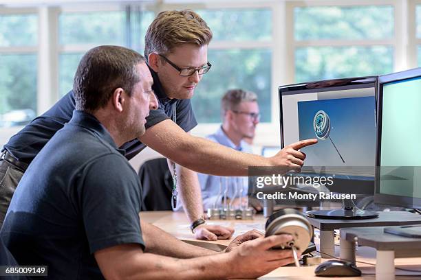 engineers discussing cad drawings onscreen of exhaust valve actuator in factory - engineer cad photos et images de collection