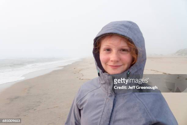 portrait of smiling caucasian girl on cold beach - kitty hawk beach stock pictures, royalty-free photos & images